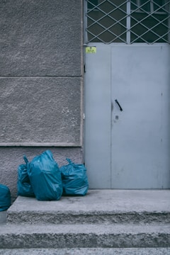 a white door with blue bags next to it