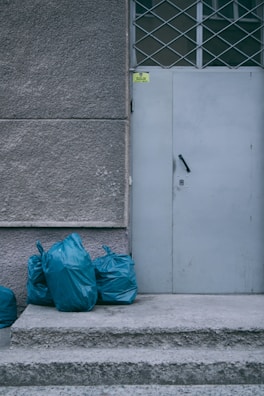 a white door with blue bags next to it