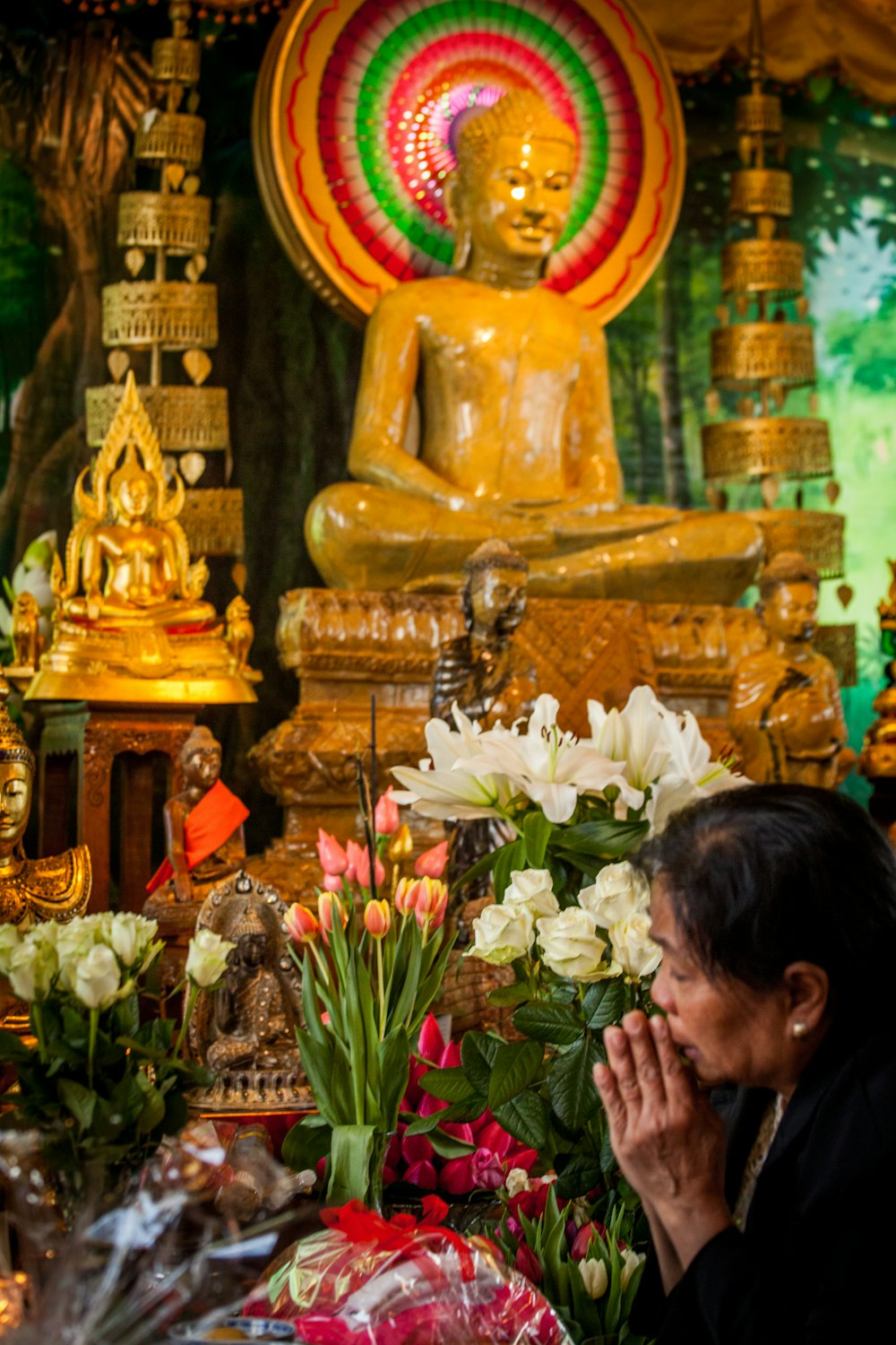 a person standing in front of a golden statue