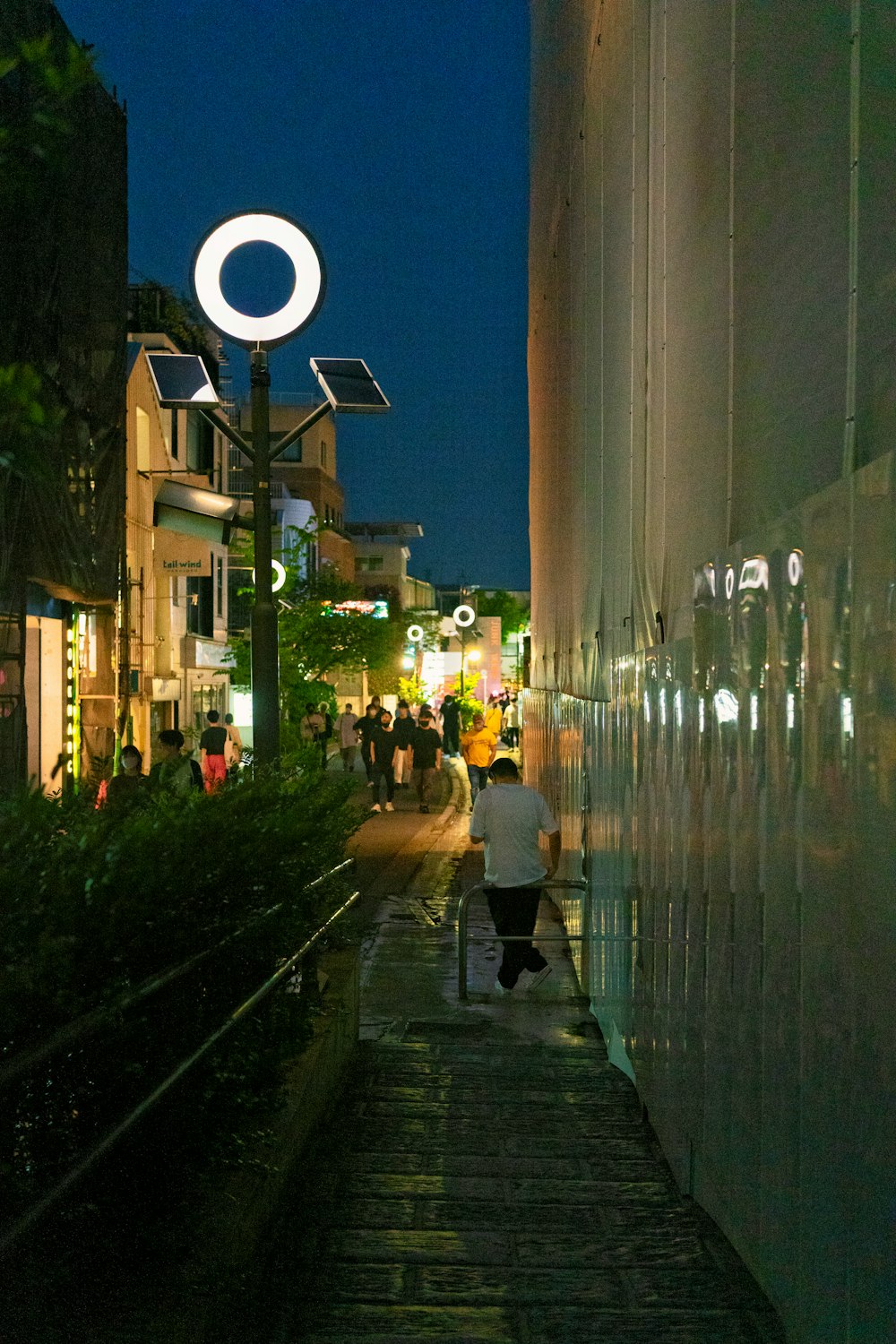 a group of people walking on a sidewalk in a city