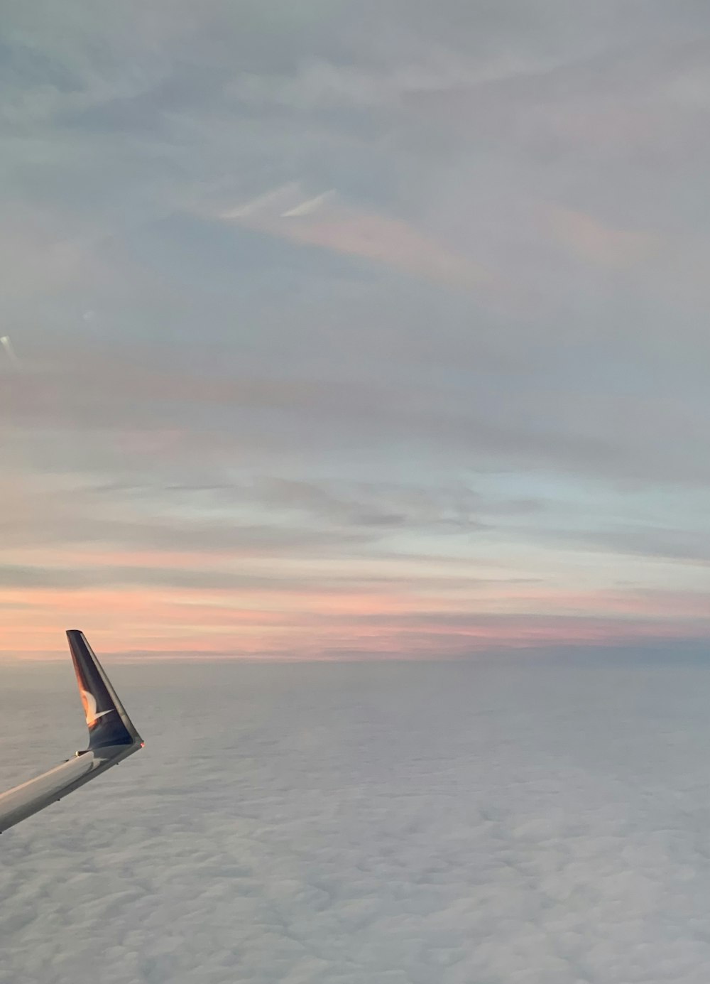 an airplane wing above the clouds