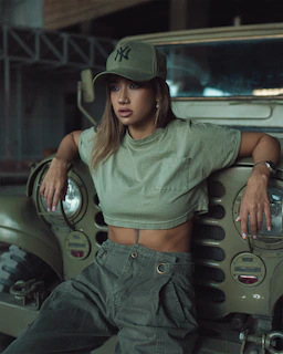 Model wearing a malakip cap outdoors, the green malachite color standing out against urban graffiti.