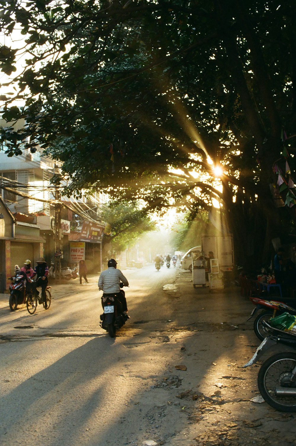 a group of people ride motorcycles down a street