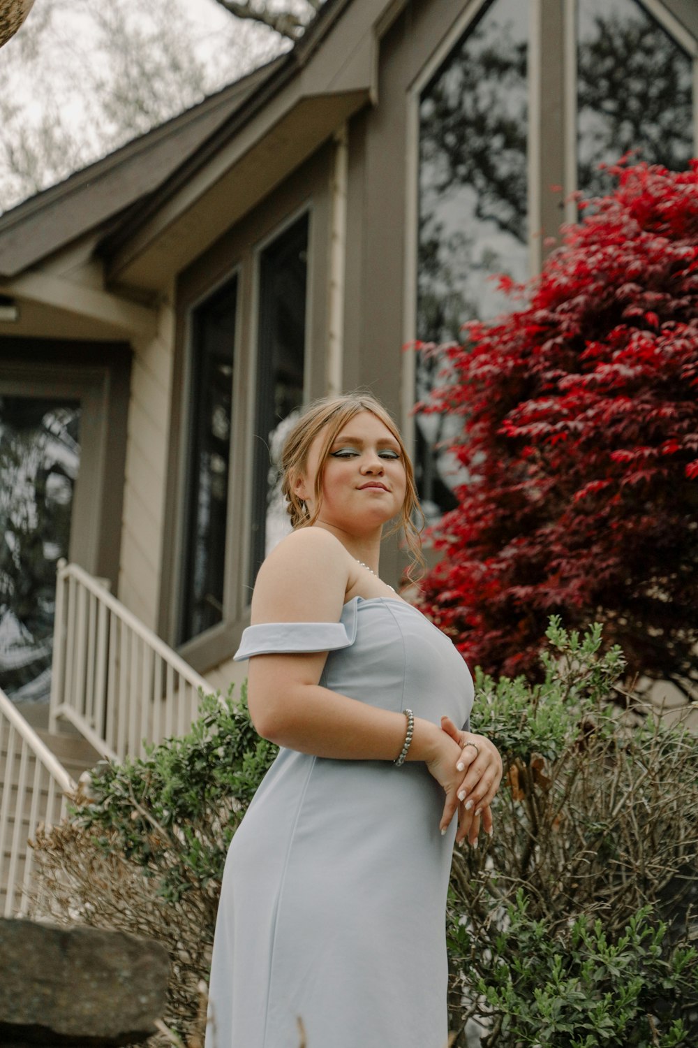 a woman in a dress standing outside a house