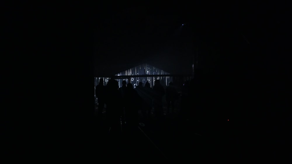 a group of people standing in a dark room