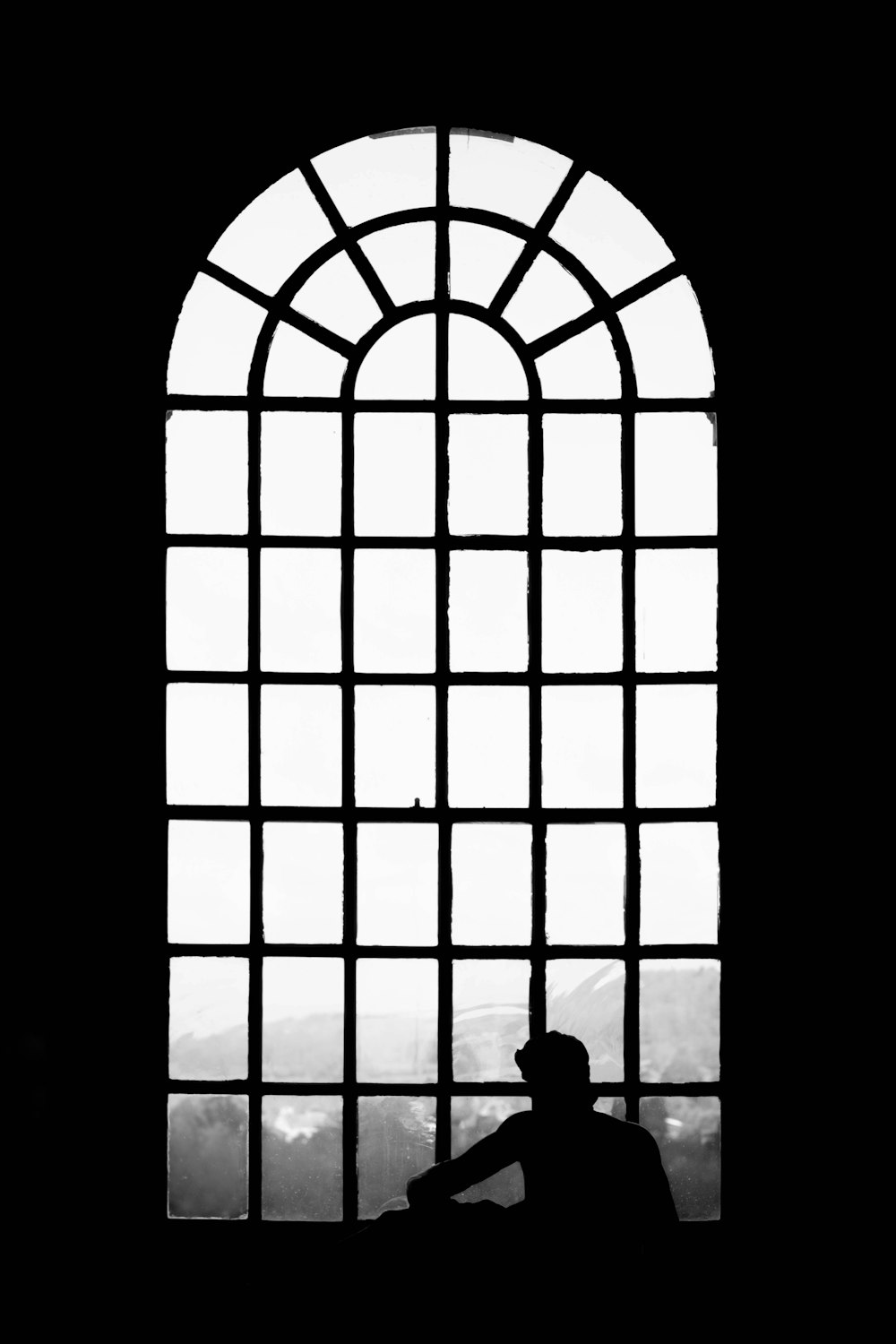 eine Person, die in einem Fenster sitzt