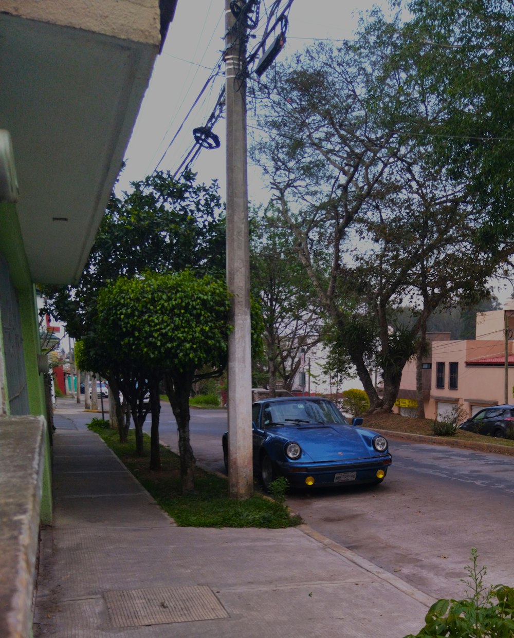 a blue car parked on the side of a street