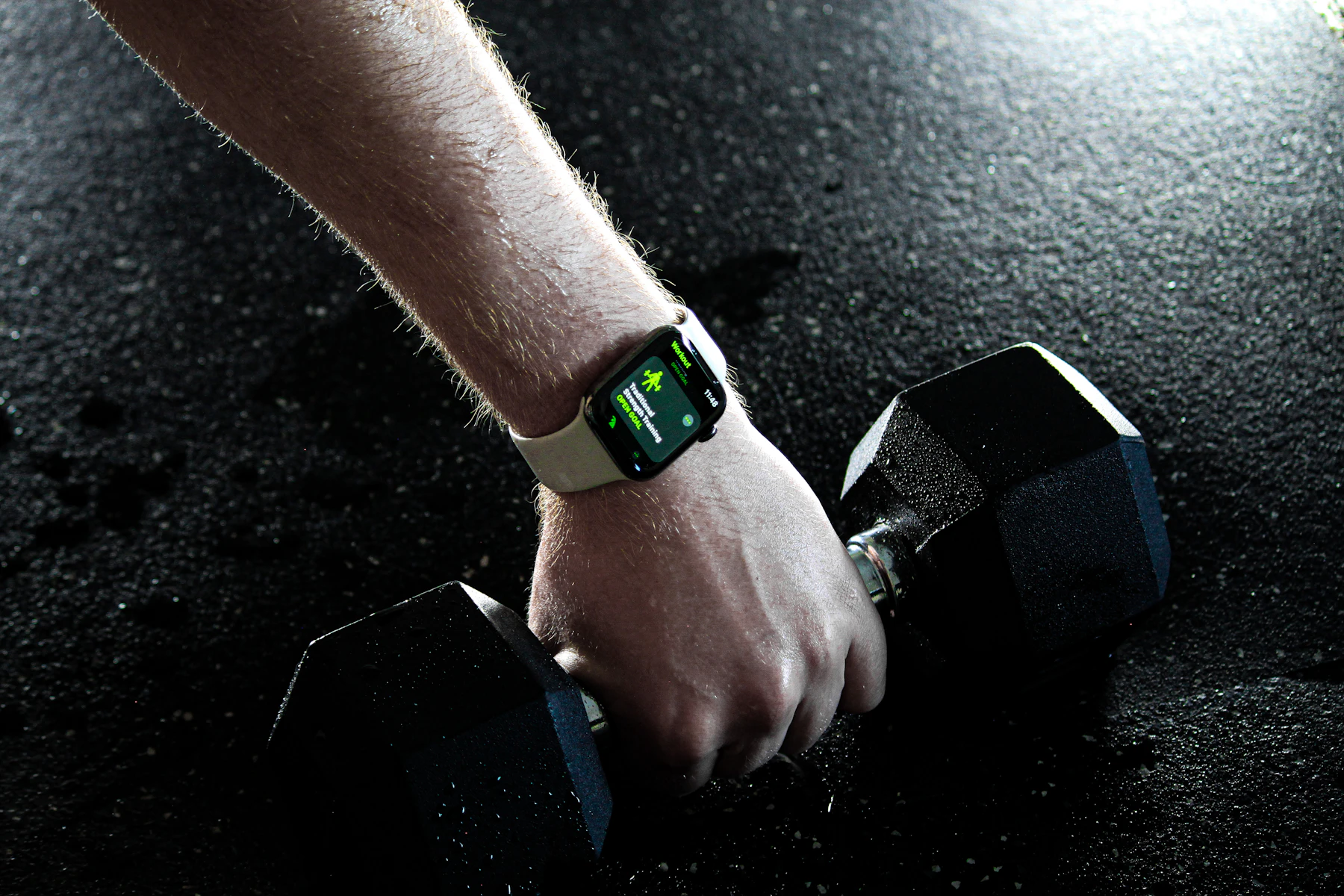 Montre connectée au poignet d'un coach à la salle de musculation, pendant une séance