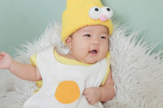 Personalized baby hats with gentle pastel tones arranged on a soft cotton cloth.