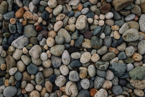 A pile of smooth river stones in various sizes, perfect for rustic home projects.