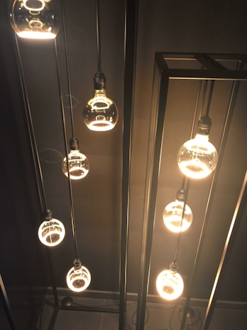 A cluster of mood spheres casting ambient light in a dim, stylish bedroom corner.