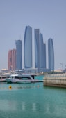 a boat in the water with tall buildings in the background