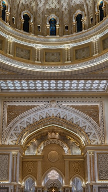 Intricate architectural details featuring ornate patterns and luxurious decorations with arches and decorative columns. The design incorporates a mix of geometric and floral motifs with a symmetrical layout, highlighted by warm lighting and rich colors.