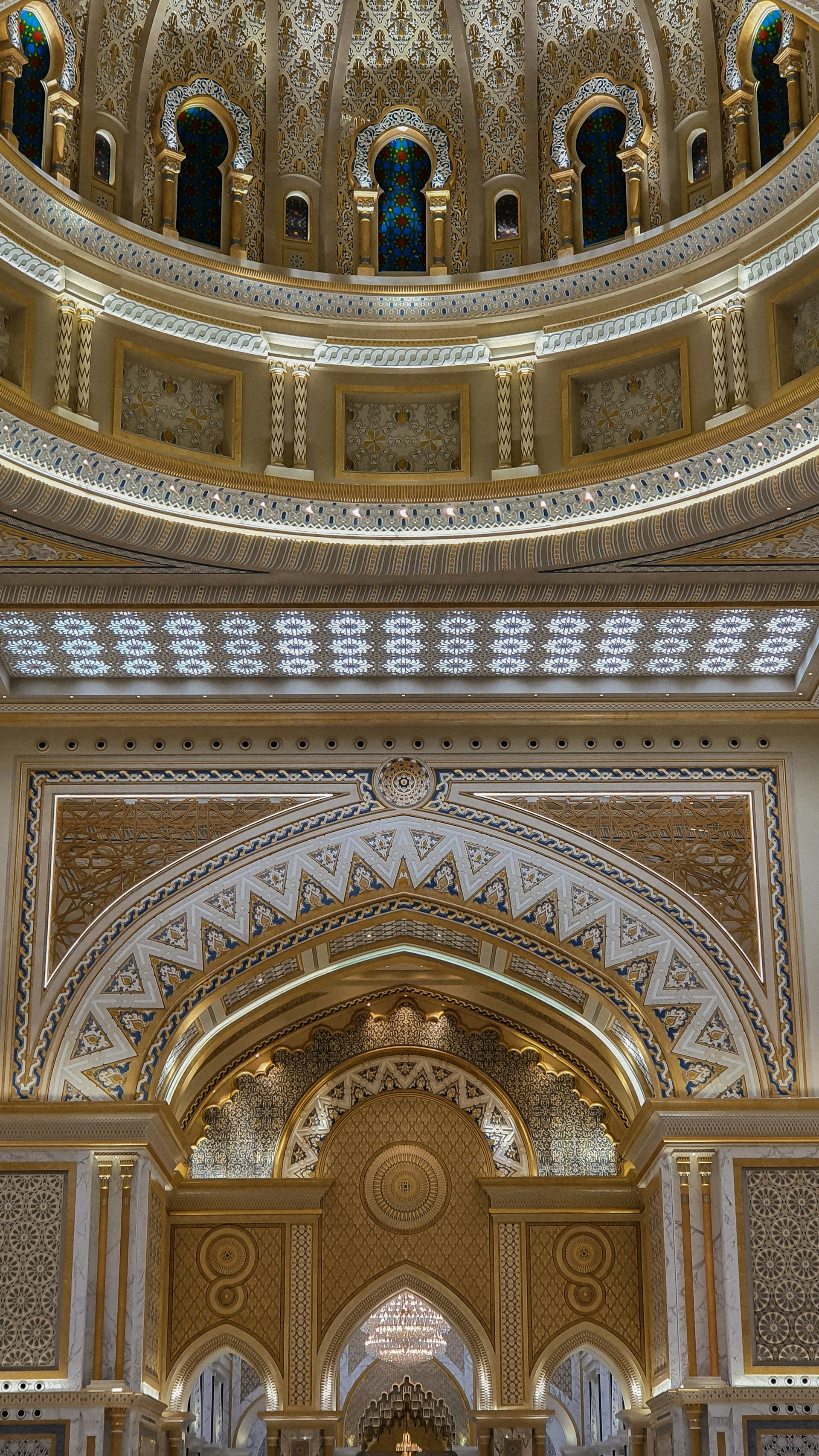 Intricate architectural details featuring ornate patterns and luxurious decorations with arches and decorative columns. The design incorporates a mix of geometric and floral motifs with a symmetrical layout, highlighted by warm lighting and rich colors.