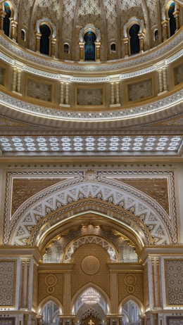 Intricate architectural details featuring ornate patterns and luxurious decorations with arches and decorative columns. The design incorporates a mix of geometric and floral motifs with a symmetrical layout, highlighted by warm lighting and rich colors.