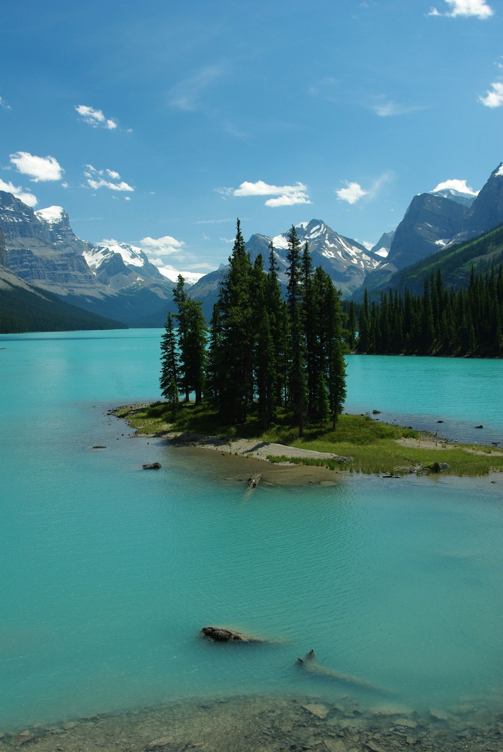 a lake with trees and mountains in the background