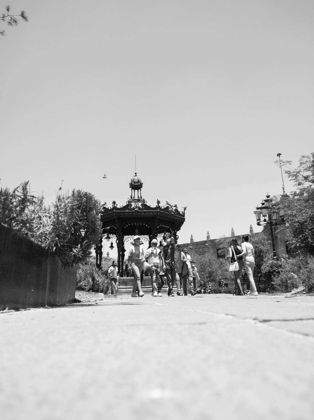 a group of people standing in front of a structure with a tower