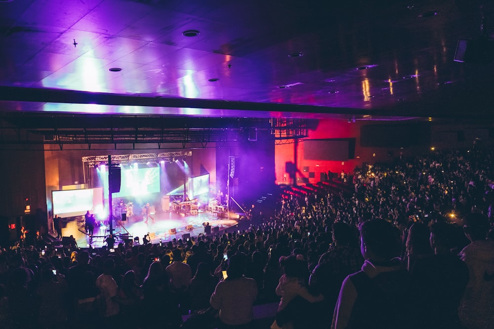 a large crowd of people in front of a stage with a large audience