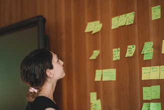 a man looking at sticky notes on a wall