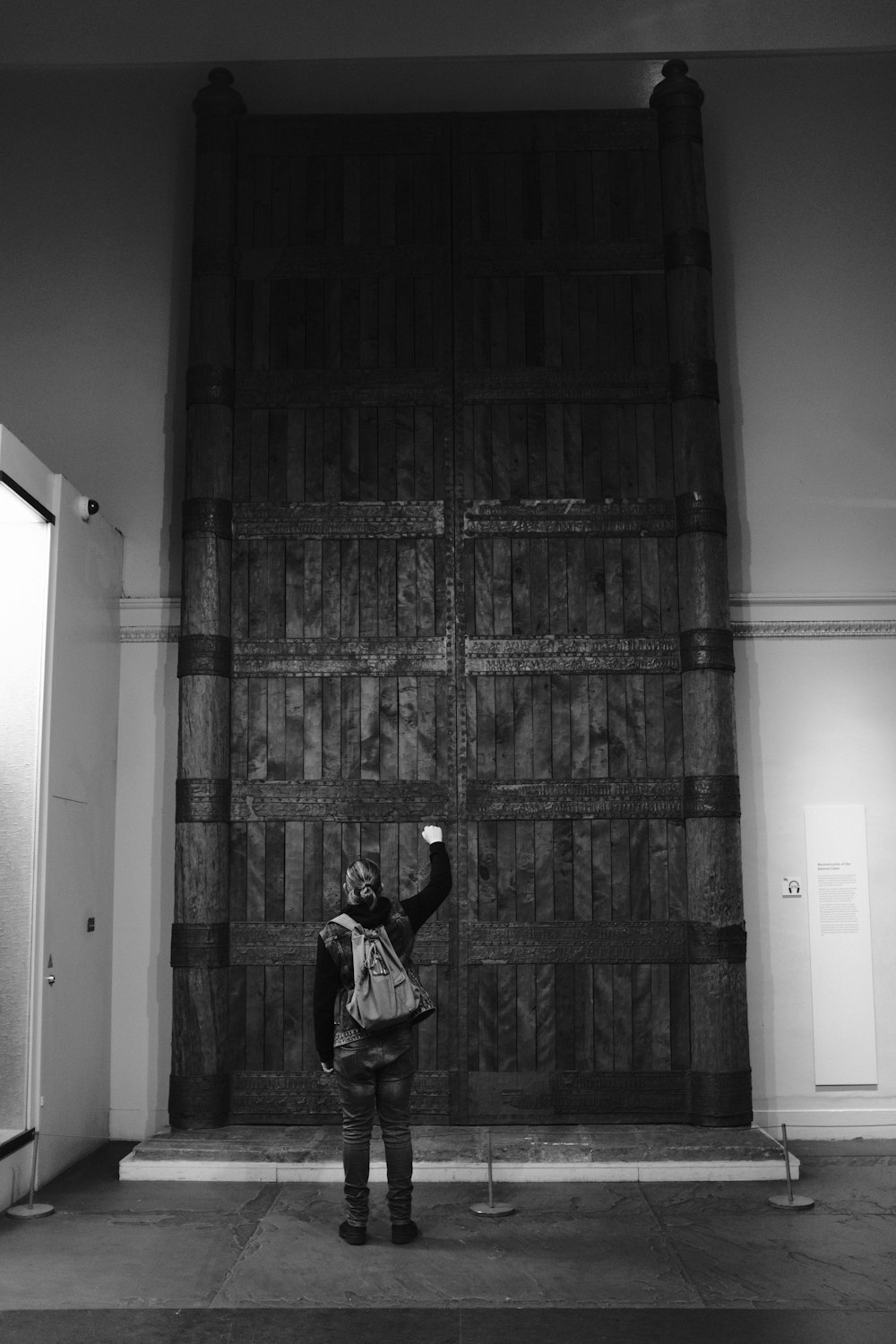 uma pessoa em pé na frente de um grande portão de metal