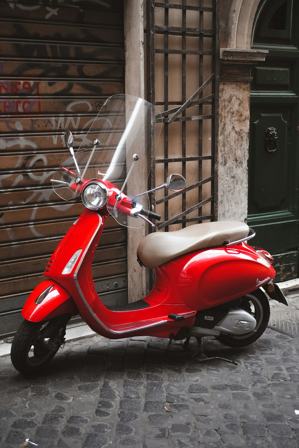 a red scooter parked on a sidewalk