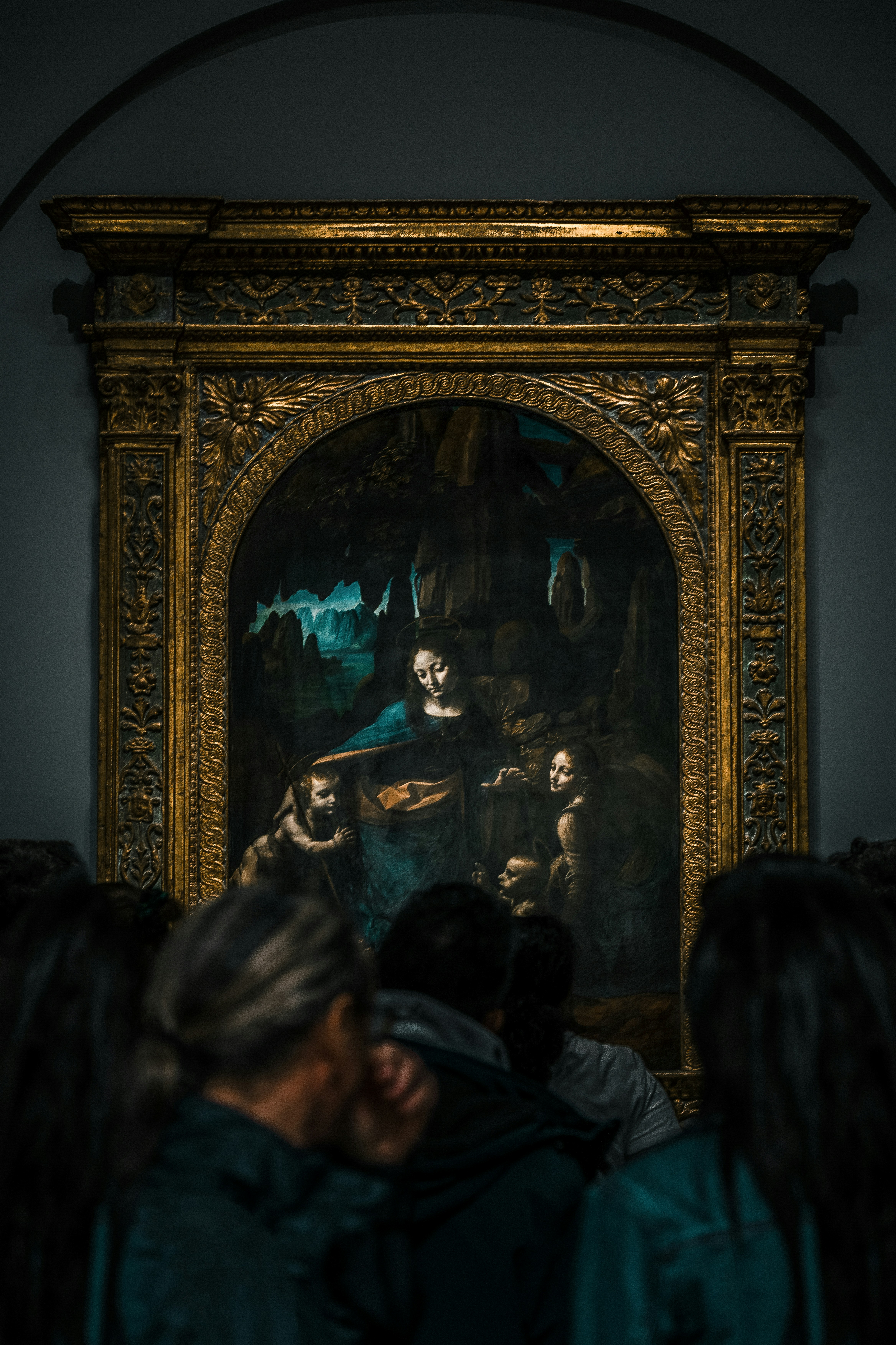 a group of people looking at a painting on a wall