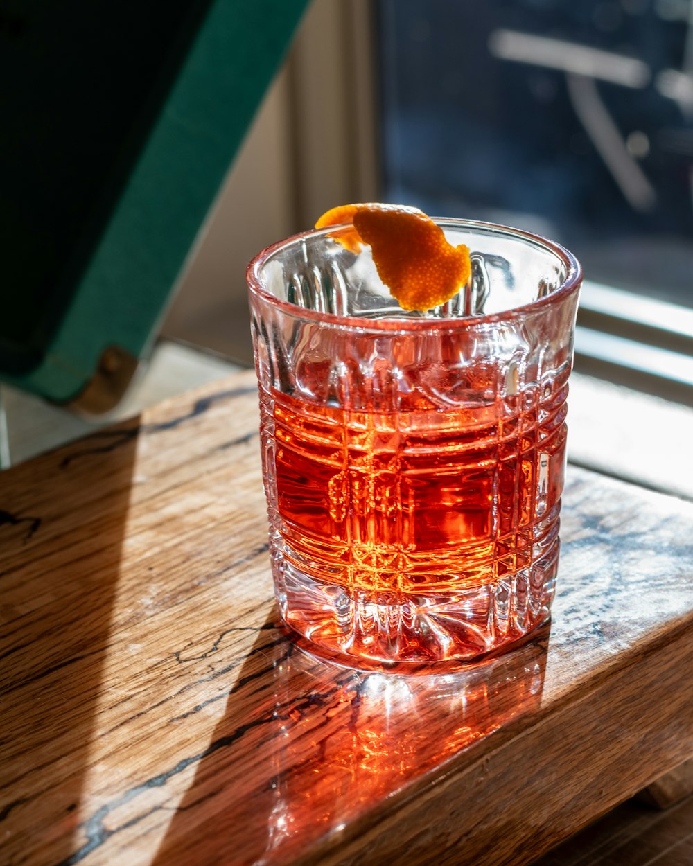 a glass of water with a slice of orange on top