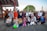 A diverse group of people smiling and holding hands in a community park.