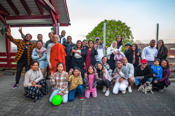 A group of diverse adults and children sharing a joyful moment outdoors.