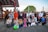 A diverse group of people smiling and holding hands in a community park.