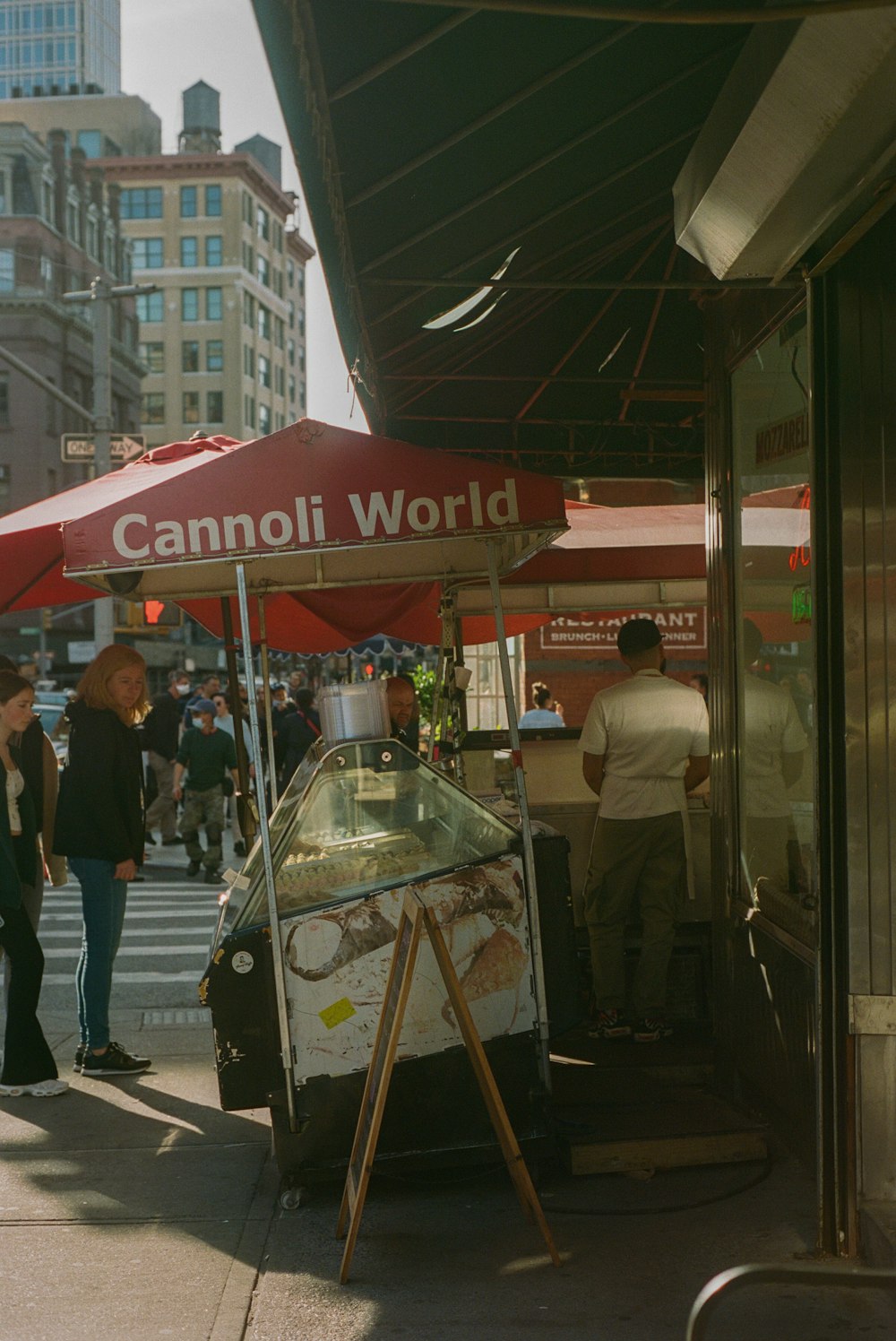 a group of people stand outside a food stand