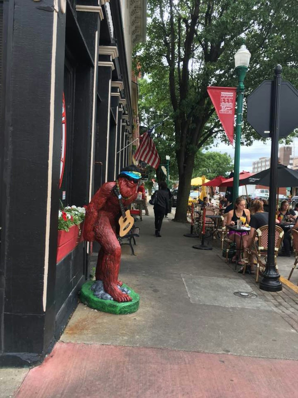 a person in a garment playing a saxophone on a sidewalk