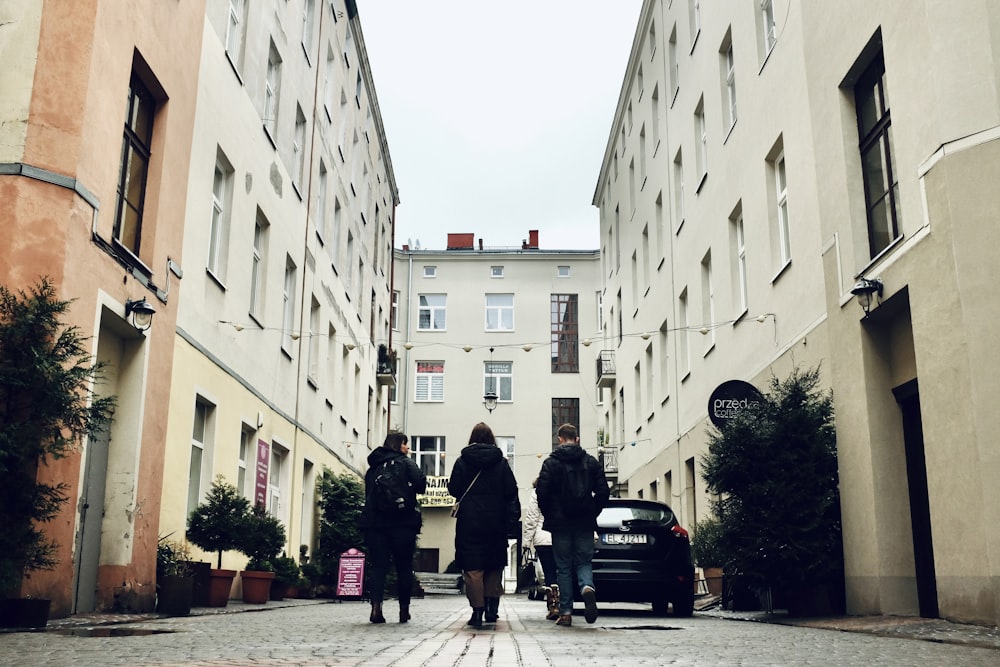 a group of people standing in a street between buildings