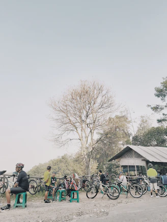 Cyclists resting and enjoying local cuisine on the terrace surrounded by lush nature.
