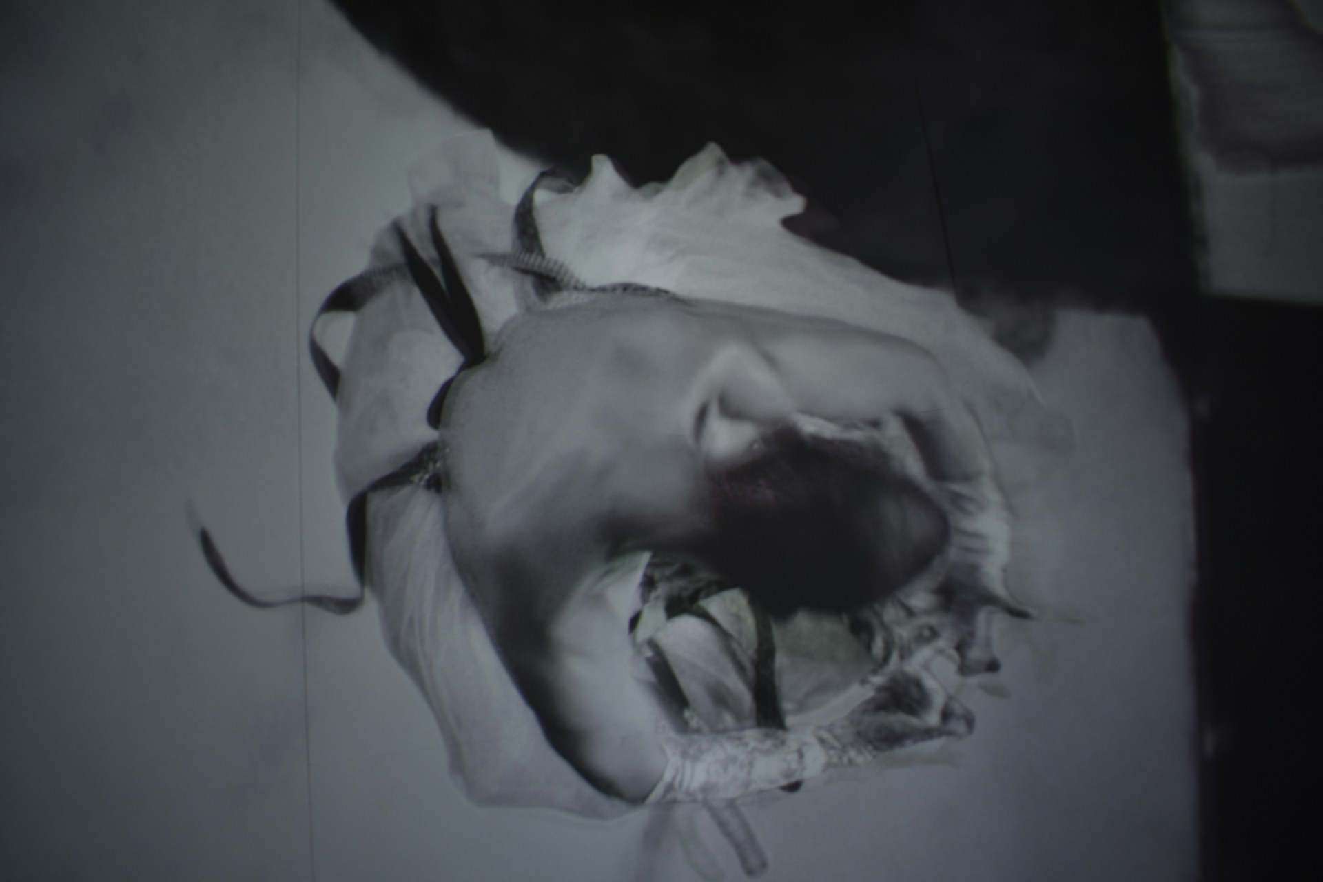 Black and white portrait of a dancer caught mid-movement, highlighting graceful lines and shadows.