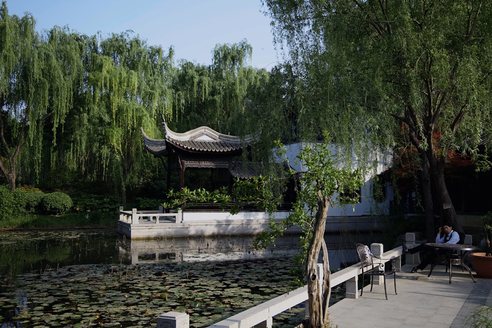 a pond with a building and trees around it