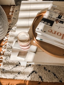 A solid wood coffee table with natural grain patterns, paired with a cozy rug.