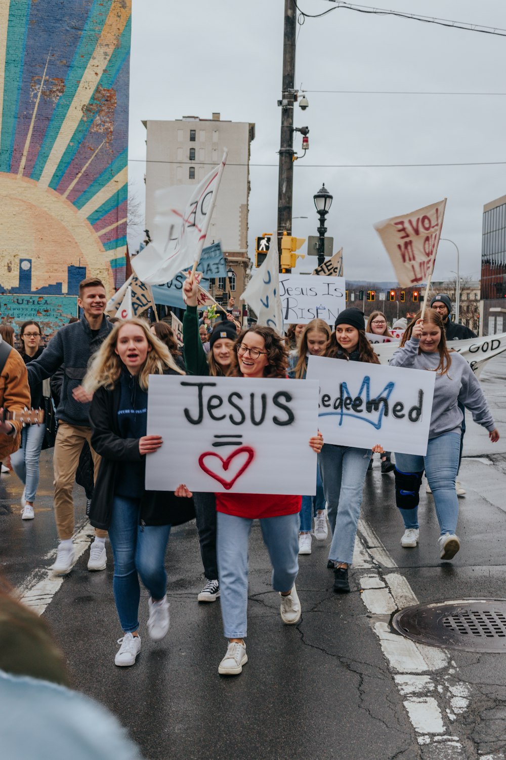 a group of people walking down a street holding signs