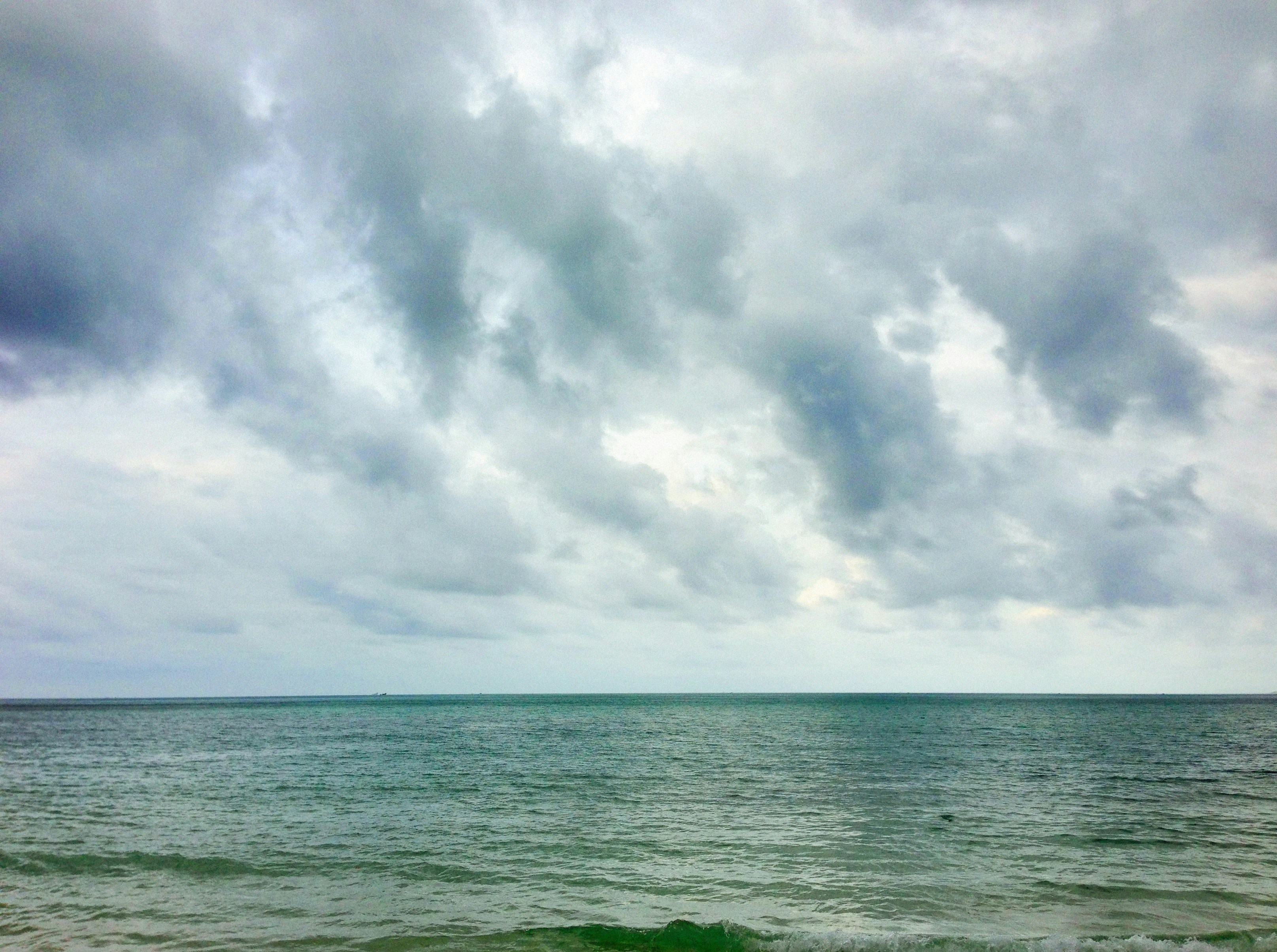 A body of water with clouds above it photo – Free Blue Image on Unsplash