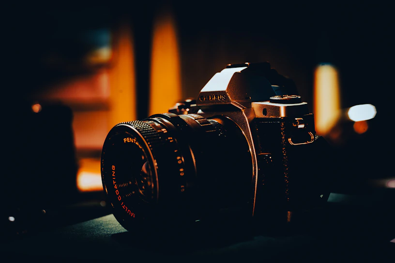 A moody close-up of a vintage film camera lens reflecting a dimly lit movie scene.