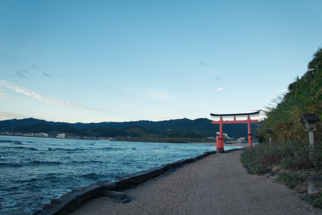 a path next to a body of water, The shrine nearby sea