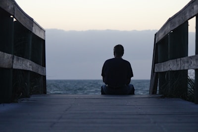 a person sitting on a dock looking out at the water