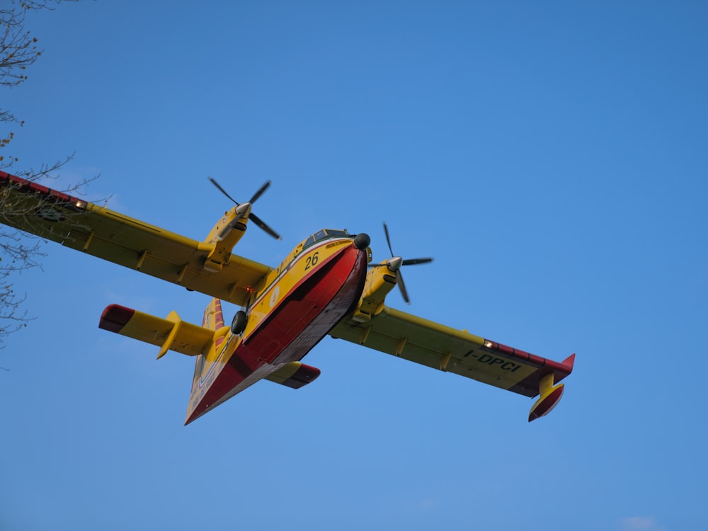 a yellow and red airplane flying