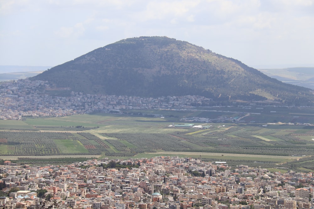 a large mountain with a town below with Mount Tabor in the background