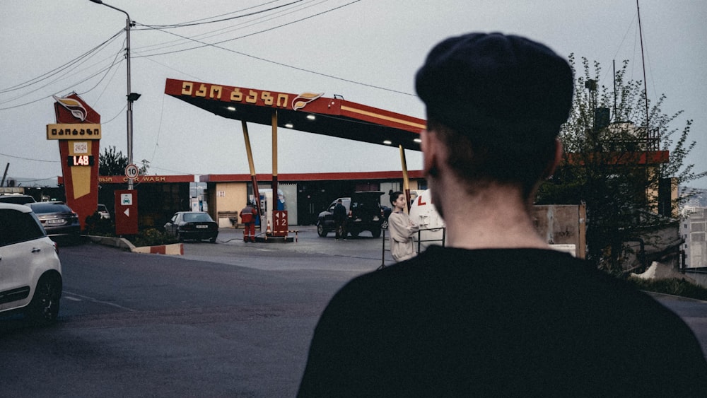 a man looking at a gas station