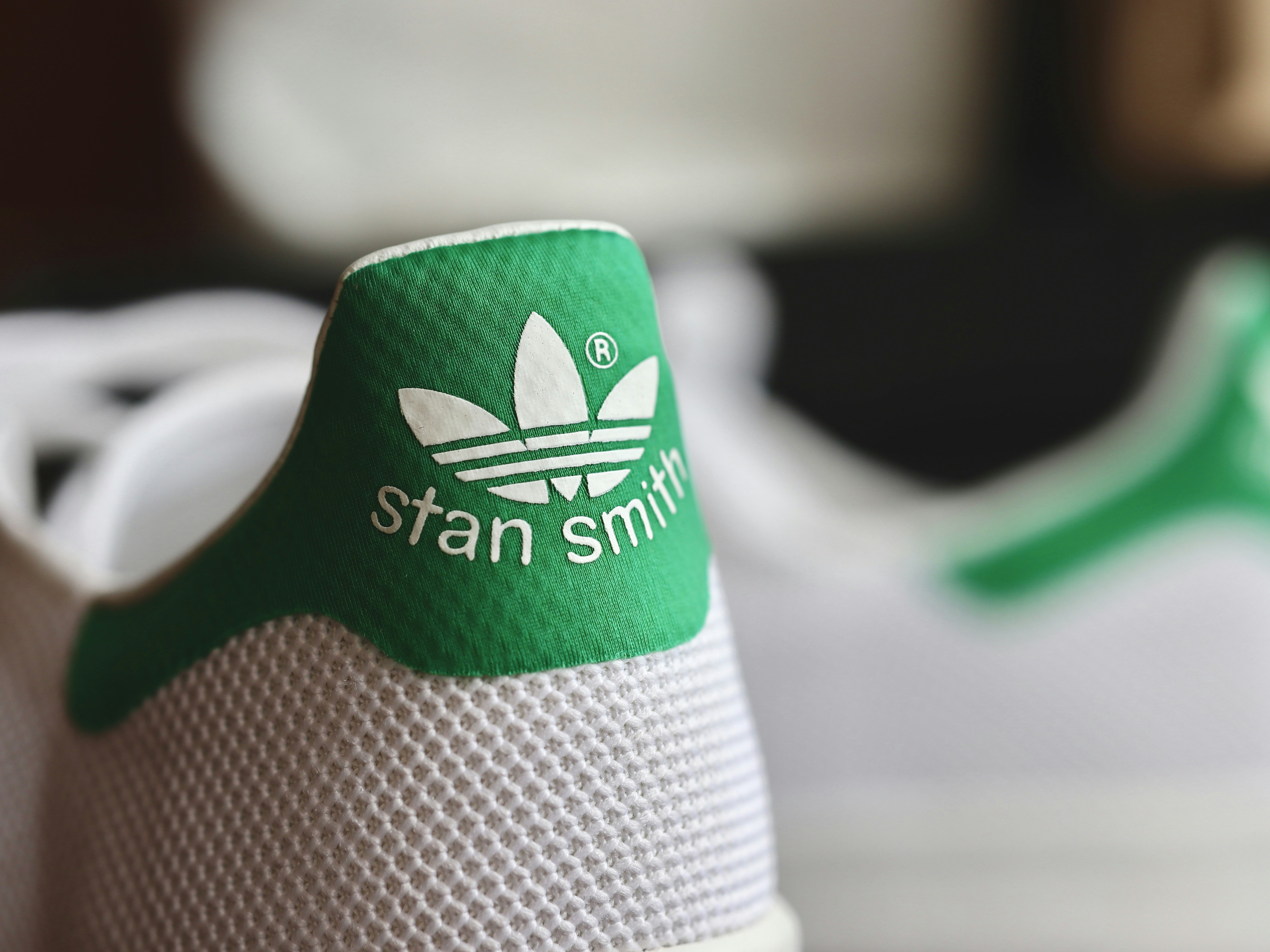 Classic white Adidas Stan Smith tennis shoe with green heel tab detail