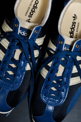 Adidas three stripes logo crisp and clear on a dark blue canvas.
