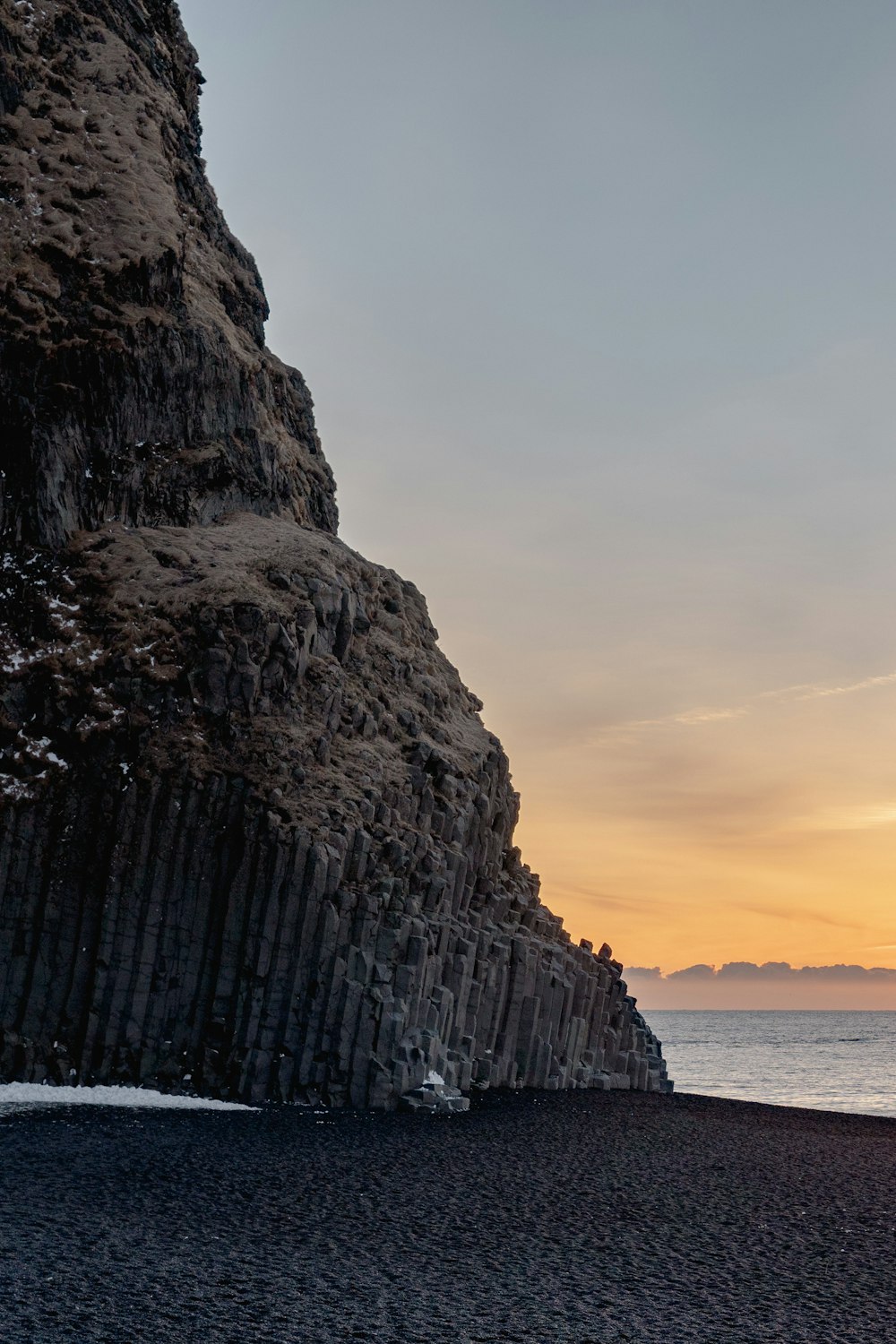 a rocky cliff next to a body of water