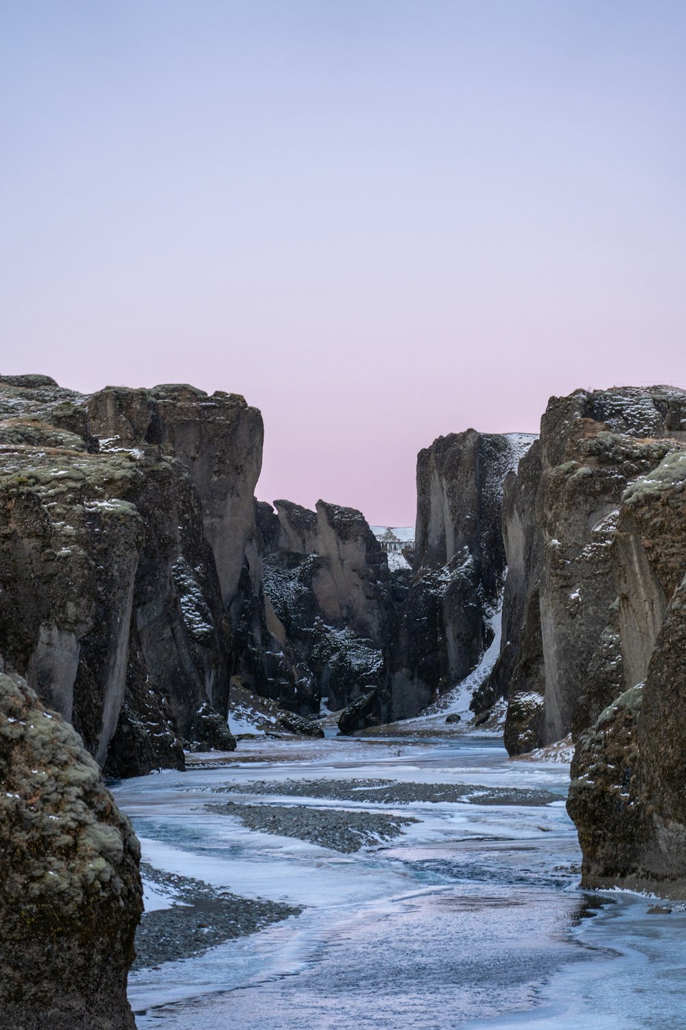 a rocky beach with a large body of water in the foreground