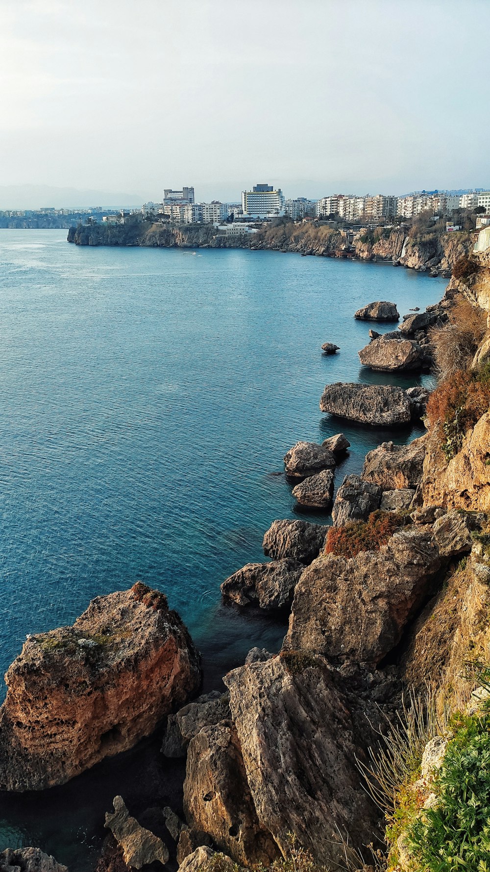 Un litorale roccioso con una città sullo sfondo